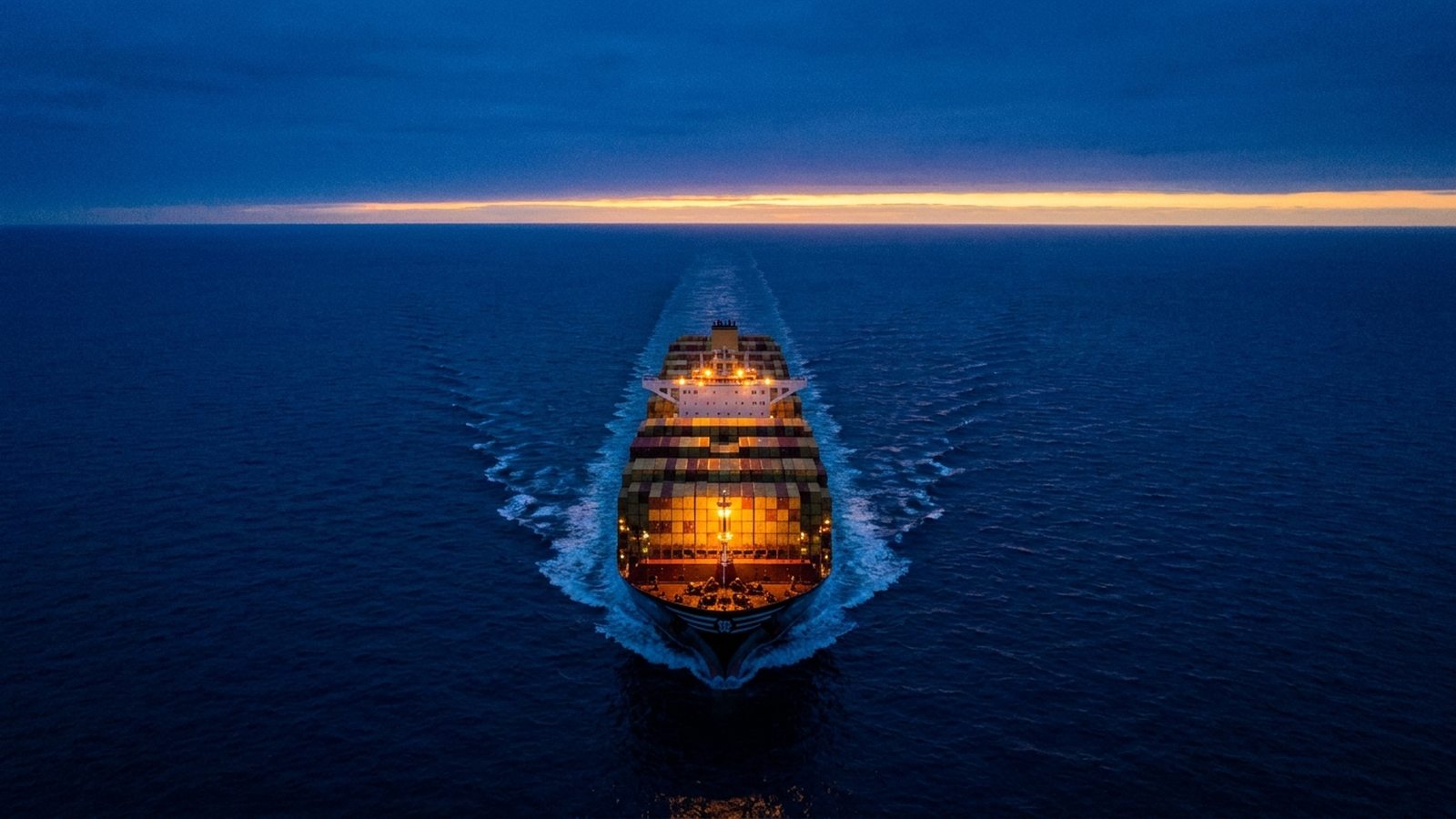 Buque portacontenedores navegando en mar abierto a la hora azul